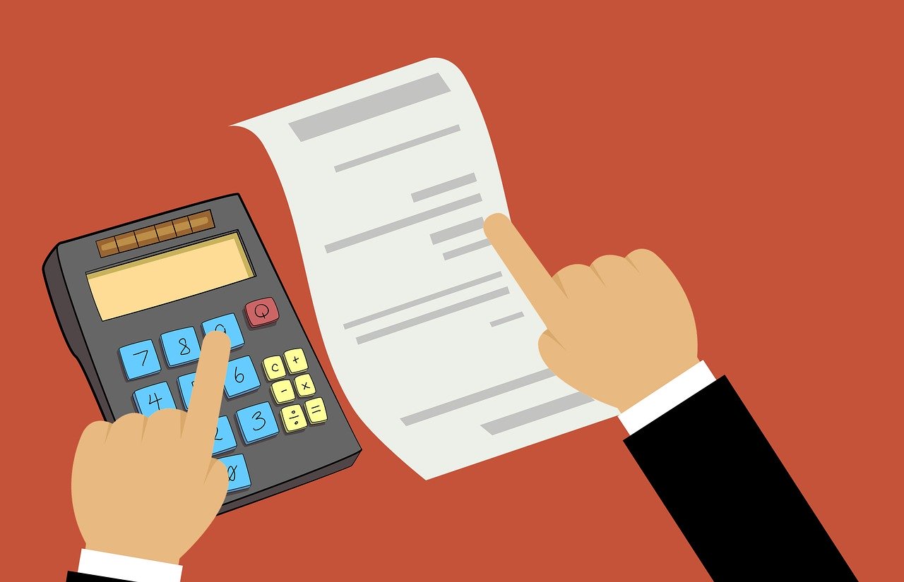 plan for tax season - fingers pointing to calculator and sheet of paper